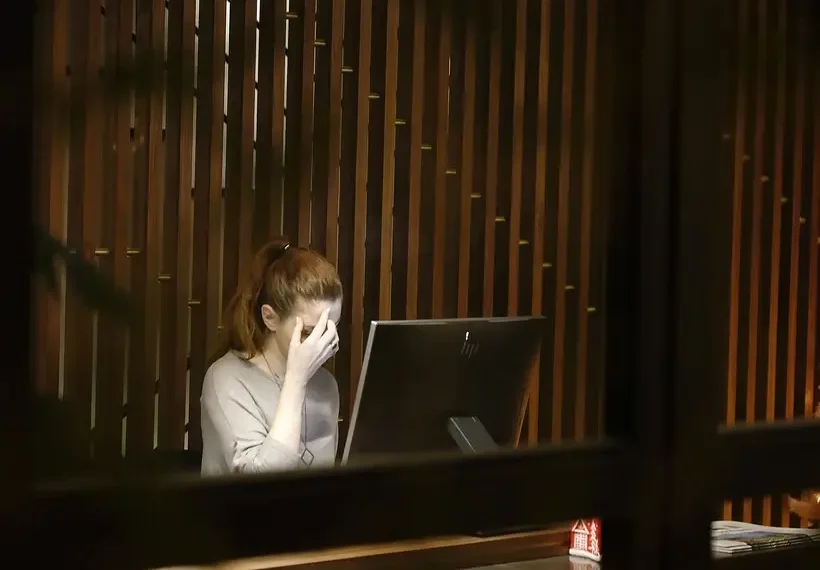 a woman sitting in front of a laptop computer